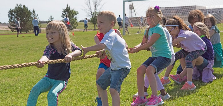 Ellicott School District and the Schriever Air Force Base Child Development Center children play tug of war during a field day at Schriever AFB, Colorado, June 20, 2019. The children participated in different activities ranging from volleyball to tug of war. (U.S. Air Force photo by Airman Jonathan Whitely)