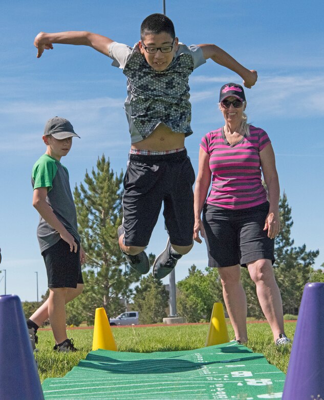 Children from the Ellicott school district and the Schriever Air Force Base child development center participate in the long jump activity during a field day at Schriever AFB, Colorado, June 20, 2019. In the activity, the children tested their standing broad jump and long jumping activities. (U.S. Air Force photo by Airman Jonathan Whitely)
