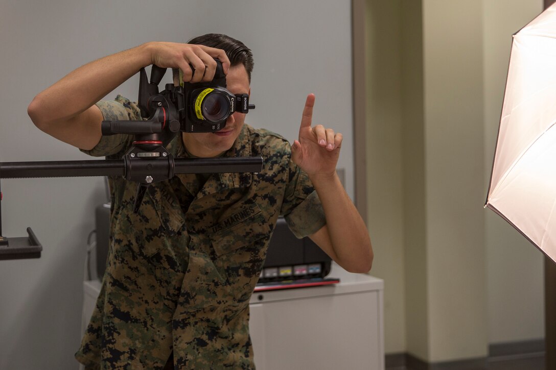 U.S. Marine Corps Lance Cpl. John Hall, a combat photographer assigned to Marine Corps Air Station (MCAS) Yuma, takes a picture in the promotion photo studio at MCAS Yuma, Ariz., June 17, 2019. As a combat photographer, Hall supports Marines aboard MCAS Yuma by taking promotion, re-enlistment, and command photos when needed. (U.S. Marine Corps photo by Sgt. Isaac D. Martinez)