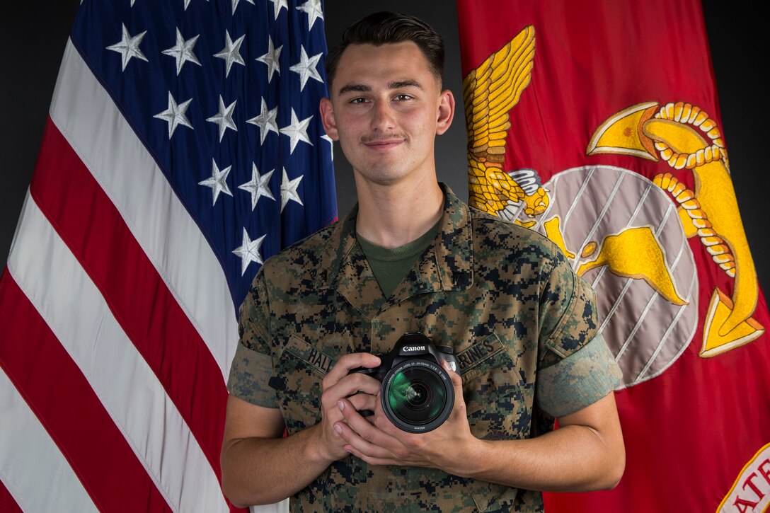 U.S. Marine Corps Lance Cpl. John Hall, a combat photographer assigned to Marine Corps Air Station (MCAS) Yuma, takes a picture in the promotion photo studio at MCAS Yuma, Ariz., June 17, 2019. As a combat photographer, Hall supports Marines aboard MCAS Yuma by taking promotion, re-enlistment, and command photos when needed. (U.S. Marine Corps photo by Sgt. Isaac D. Martinez)