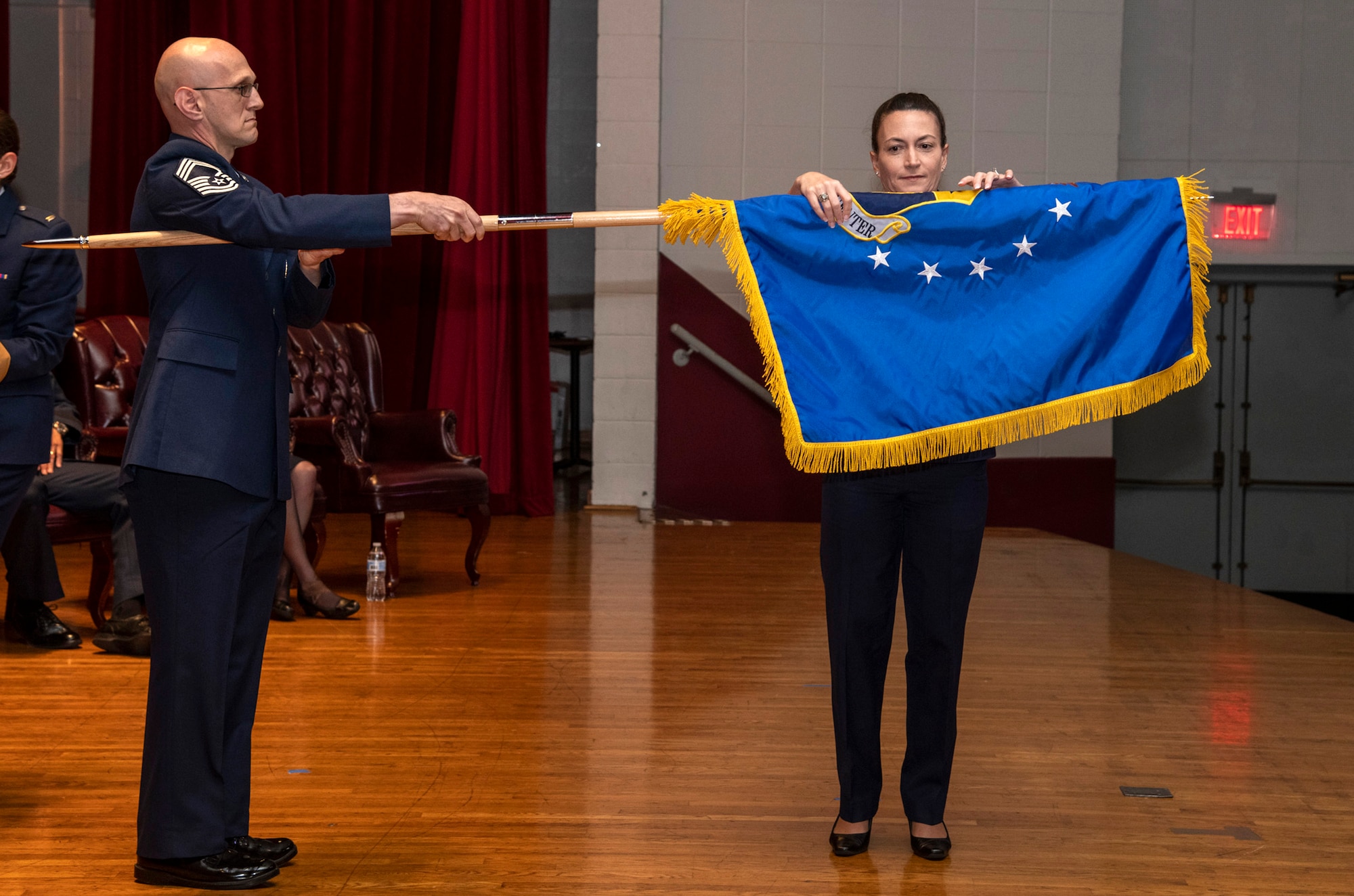 Col. Donna Turner, commander of the newly named Air Force Services Center, unfurls her unit's new flag at a special ceremony June 25, 2019, on Joint Base San Antonio-Lackland, Texas. The Air Force Installation and Mission Support Center formally redesignated AFSVC and the Air Force Installation Contracting Center-- two of its primary subordinate units -- to bring them in line with Air Force naming conventions. (U.S. Air Force photo by Johnny Saldivar)