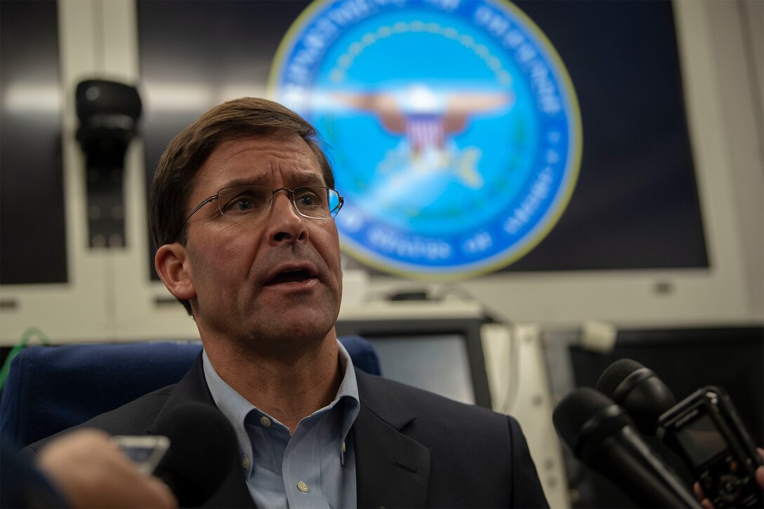 Acting Defense Secretary Mark T. Esper speaks with reporters on a government aircraft.