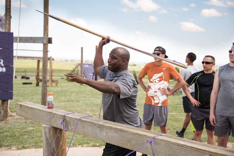 Lt. Col. Anthony Lang, 50th Space Communications Squadron commander, throws a spear during the obstacle course challenge at PCR Fitness, Colorado Springs, Colorado, June 21, 2019. This event helped the Airmen work on their resilience while performing rigorous physical activities on the obstacle course. (Air Force photo by 2nd Lt. Idalí Beltré Acevedo)