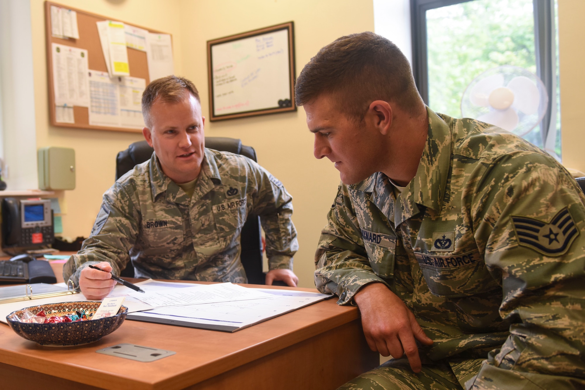 U.S. Air Force Master Sgt. Curtis L. Brown, 100th Force Support Squadron career assistance advisor, speaks with Staff Sgt. William E. Baynard, 100th Civil Engineer Squadron pavements and equipment craftsman, about career options at RAF Mildenhall, England, June 12, 2019. Brown counsels Airmen on retraining, reenlistment, separation, military benefits and commissioning opportunities. (U.S. Air Force photo by Airman 1st Class Joseph M. Barron)