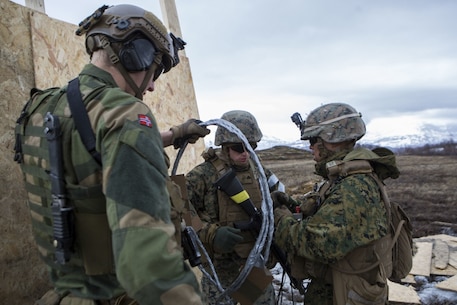 U.S. Marines with 8th Engineer Support Battalion, 2nd Marine Logistics Group, and a Norwegian soldier prepare to arm a breaching charge during an urban-breaching range in Skjold Leir, Norway, May 29, 2019. The Marines of 8th ESB deployed to Norway to participate in exercise Thunder Reindeer 19, a multilateral, combined-arms, live-fire exercise between the Norwegian Armed Forces and U.S. Marine Corps. Training conducted during the deployment increases interoperability with Norwegian allies, and improves the Marine Corps’ cold-weather and mountain-warfare proficiencies. (U.S. Marine Corps photo by Lance Cpl. Larisa Chavez)