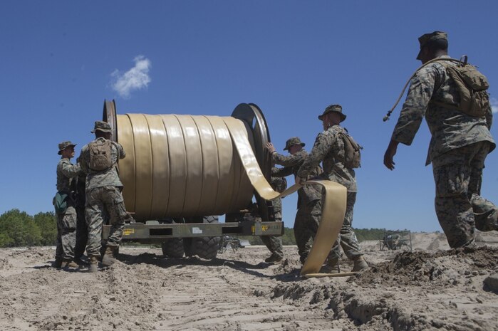 U.S. Marines with Bulk Fuel Company, 8th Engineer Support Battalion (ESB), 2nd Marine Logistics Group, utilize a hose-reel system to lay down a fuel line during a Bulk Fuel exercise at Camp Lejeune, North Carolina, June 19, 2019. The Marines with 8th ESB ran fuel lines, patrolled the fuel sites and provided all around security to remain proficient in fueling support operations. (U.S. Marine Corps photo by Lance Cpl. Adaezia L. Chavez)