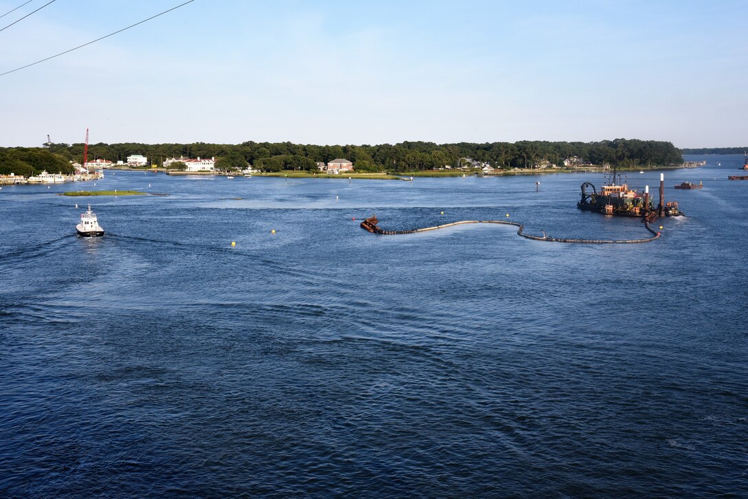 A view of the dredge boat and a pipeline floating above the water on the Lynnhaven Inlet
