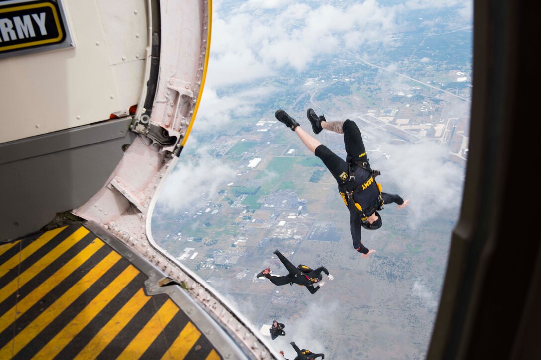 Soldiers jump out of a plane.