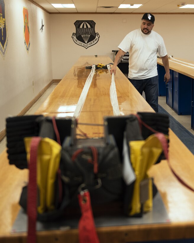 Juan Gonzalez, 56th Operations Support Squadron Aircrew Flight Equipment technician, straightens out parachute suspension lines June 20, 2019, at Luke Air Force Base, Ariz.