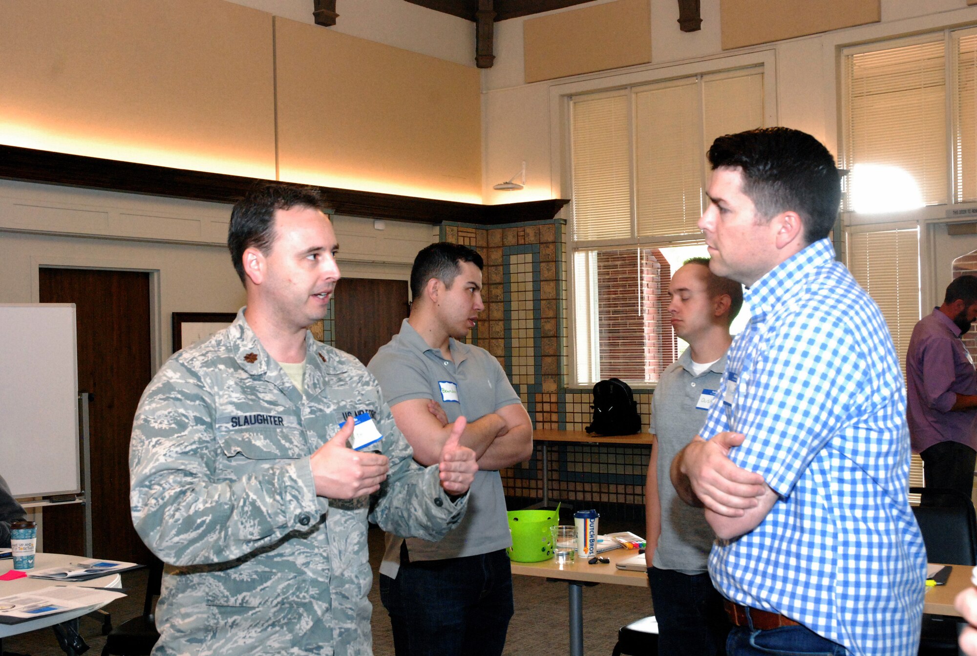 PETERSON AIR FORCE BASE, Colo. - Maj. Robert Slaughter discusses the Combat Development Division with an Airman. The model's differences from traditional acquisition means that implementation requires a degree of intrapreneurship — salesmanship with the organization. (Photo by Griffin Swartzell)