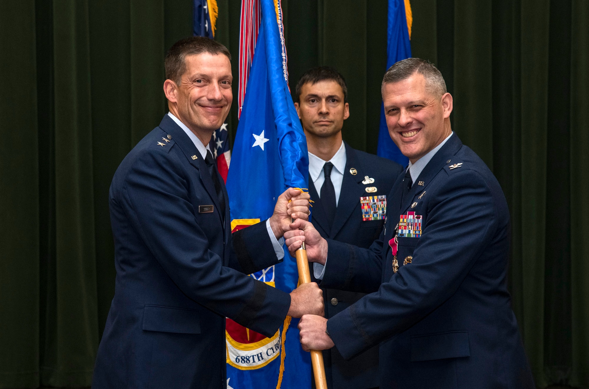 Col. Eric DeLange (right) relinquishes command of the 688th Cyberspace Wing to Maj. Gen. Robert Skinner, 24th Air Force commander, during the wing’s change of command ceremony at Joint Base San Antonio-Lackland, Texas, June 25, 2019. Col. Steven Anderson took command of the 688th CW during the ceremony. (U.S. Air Force photo by Johnny Saldivar)