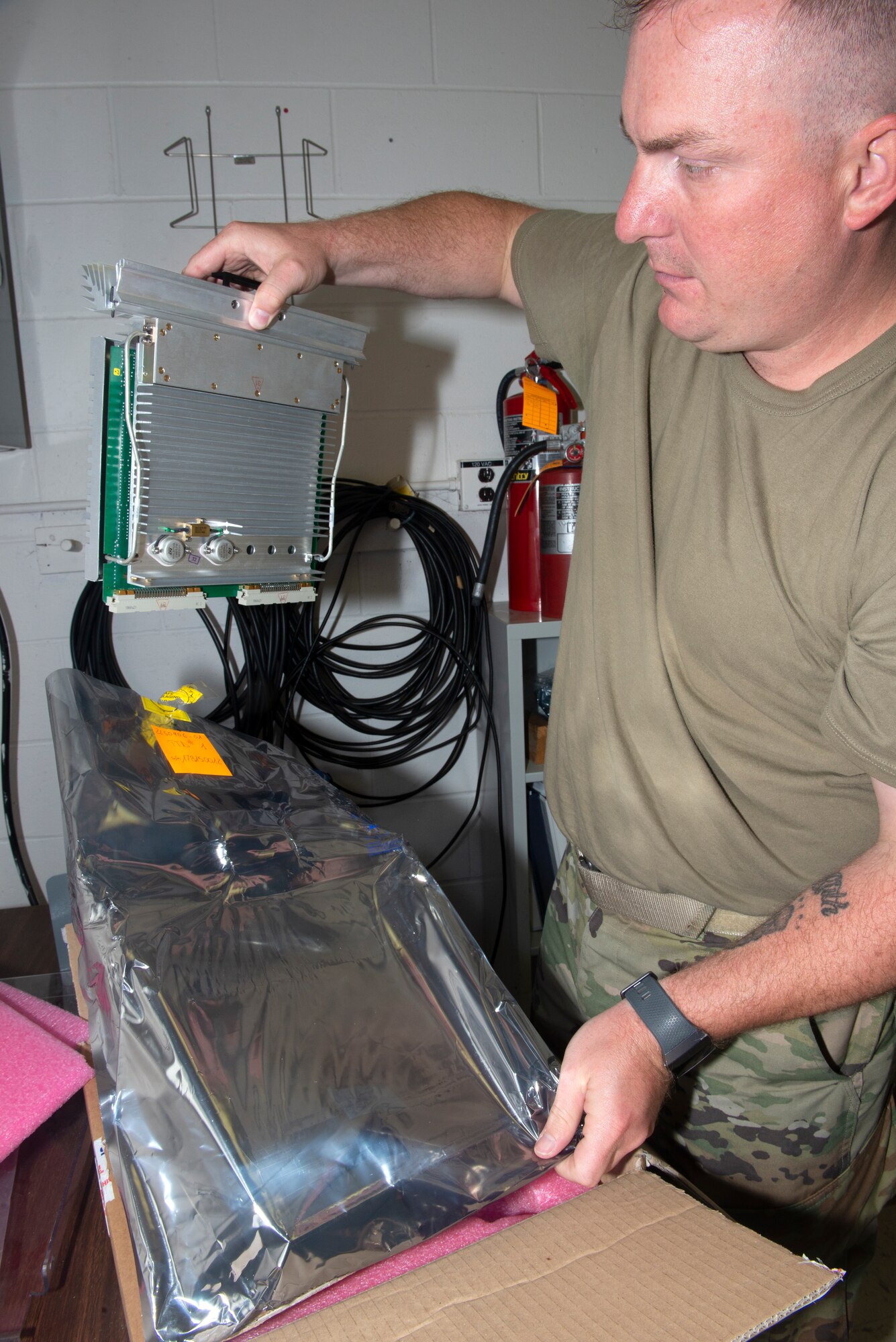 Master Sgt. Travis Meyer, 55th Operational Support Squadron Radar Airfield Weather Systems section chief, pulls out a component to be installed into the new Tactical Air Navigation System rack and transponder cabinet June 22, 2019, at Offutt Air Force, Nebraska. The TACAN rack which was still under contract, is being provided at no cost to Offutt saving approximately $375,000. (U.S. Air Force photo by L. Cunningham)