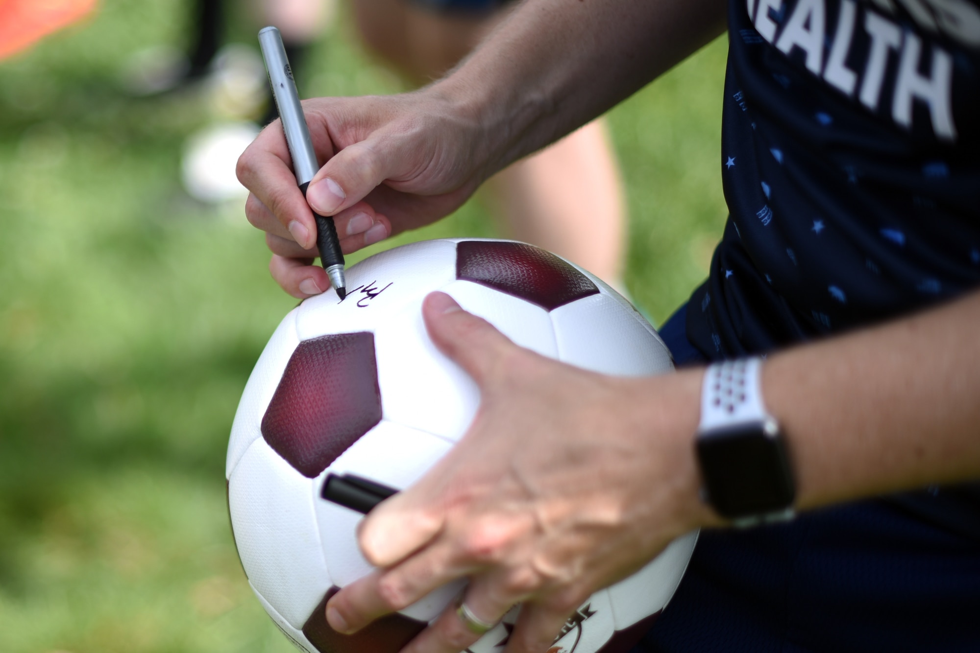 Ben Gumpert, Sacramento Republic Football Club president and chief operations officer, signs a soccer ball for an Airman June 24, 2019, at Travis Air Force Base, California. The Republic FC staff members toured a C-5M Super Galaxy and learned about the Travis AFB mission ahead of their “Salute to Service Night.” (U.S. Air Force photo by Senior Airman Christian Conrad)