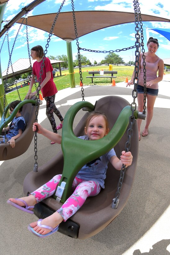Skylar and her mother, Debbra Harvey, enjoy the new, all-abilities playground at Centennial Park June 24, 2019, at Hill Air Force Base, Utah. The playground is wheelchair accessible and incorporates sensory areas with a mixture of music- and texture-focused equipment for children. (U.S. Air Force photo by Todd Cromar)