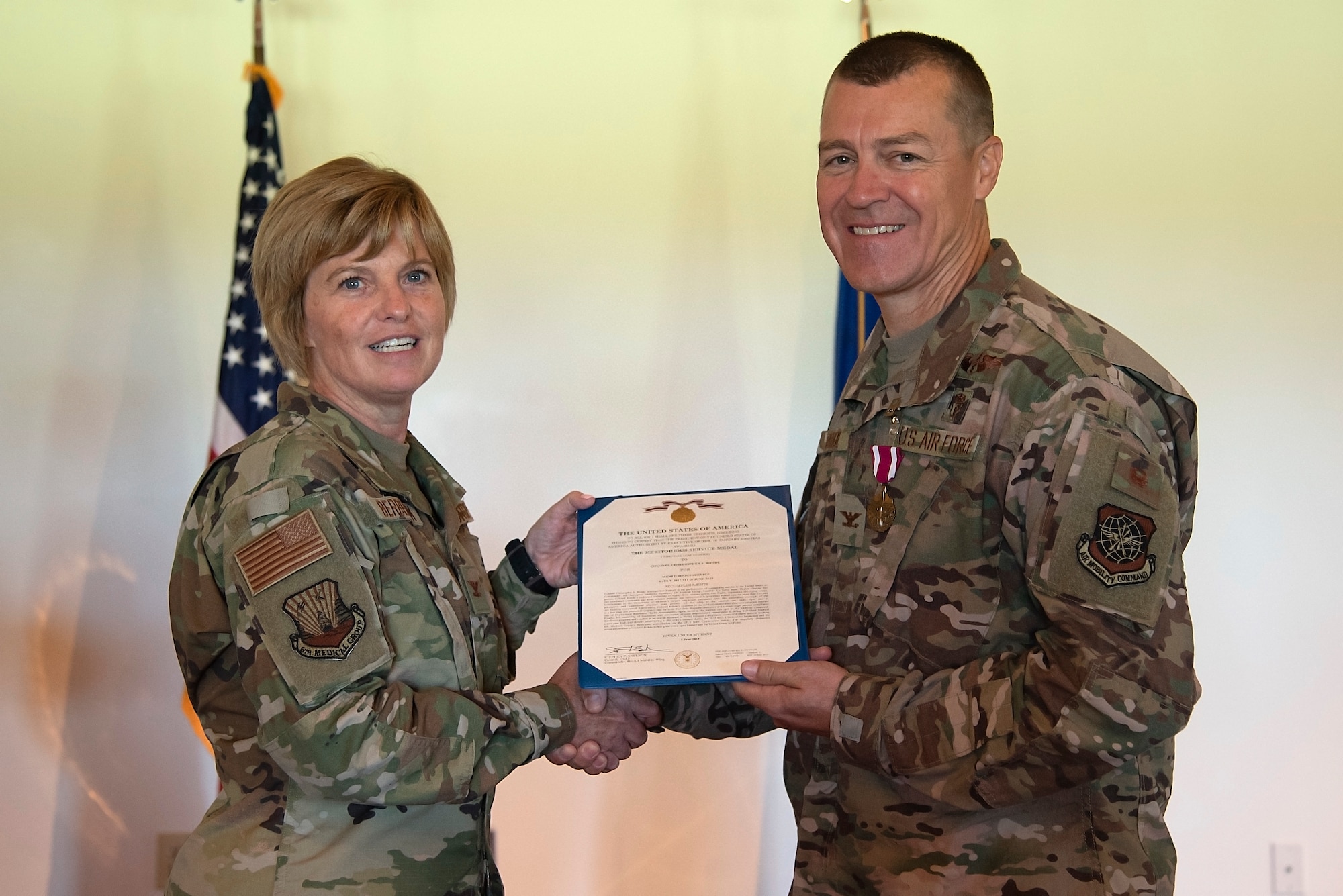 U.S. Air Force Col. Christine Berberick, the 6th Medical Group commander, gives Col. Christopher Rohde, the 6th Aerospace Medical Squadron commander, a meritorious service award at MacDill Air Force Base, Fla., June 14, 2019.