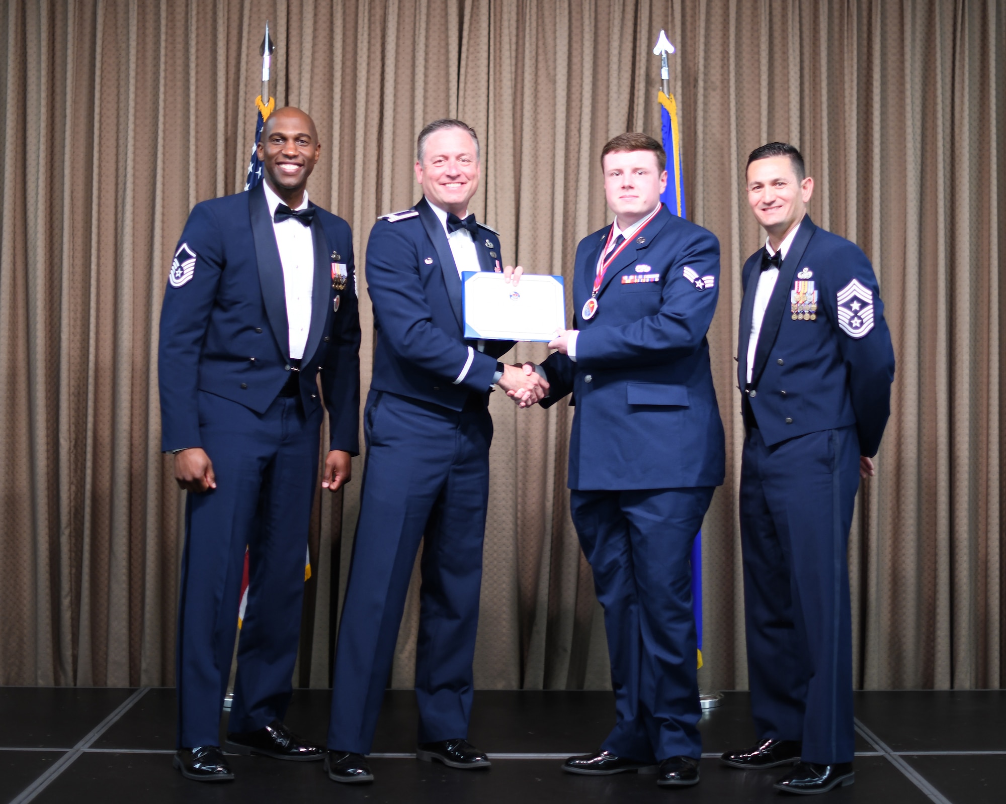 Col. Benjamin Spencer, 319th Air Base Wing commander, presents diploma to SrA Carery Amorine, Etchberger Airman Leadership School graduate, June 20, 2019, on Grand Forks Air Force Base, North Dakota. ALS graduation is the culmination of the first level of the Enlisted Professional Military Education continuum directed toward preparing upcoming noncommissioned officers with leadership skills for their careers. (U.S. Air Force photo by Senior Airman Elijaih Tiggs)