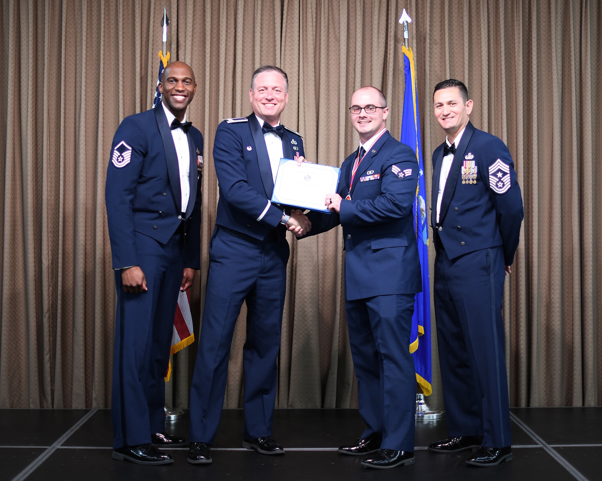 Col. Benjamin Spencer, 319th Air Base Wing commander, presents diploma to SrA Michael Coleman, Etchberger Airman Leadership School graduate, June 20, 2019, on Grand Forks Air Force Base, North Dakota. ALS graduation is the culmination of the first level of the Enlisted Professional Military Education continuum directed toward preparing upcoming noncommissioned officers with leadership skills for their careers. (U.S. Air Force photo by Senior Airman Elijaih Tiggs)
