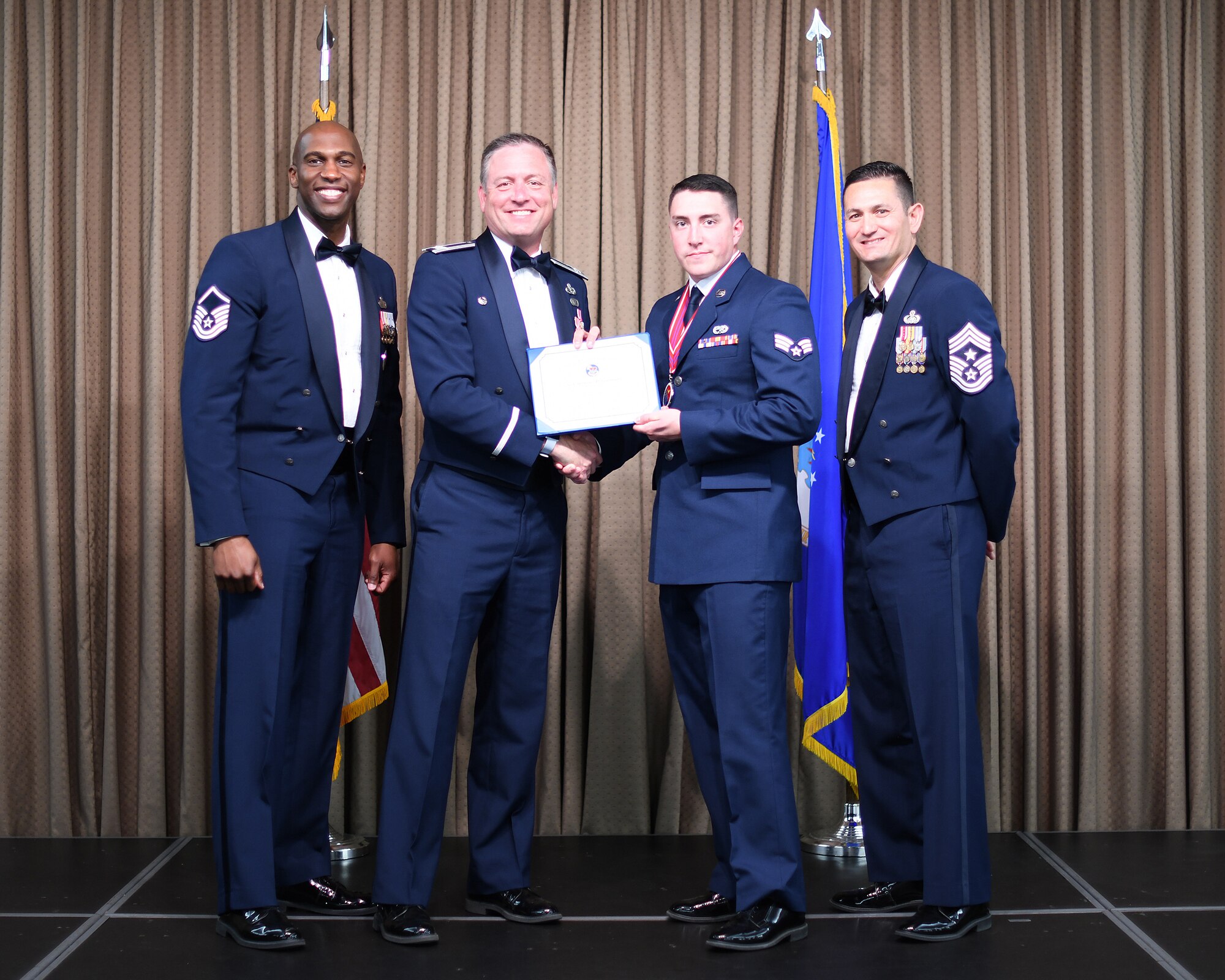 Col. Benjamin Spencer, 319th Air Base Wing commander, presents diploma to SrA Anthony Coronato, Etchberger Airman Leadership School graduate, June 20, 2019, on Grand Forks Air Force Base, North Dakota.ALS graduation is the culmination of the first level of the Enlisted Professional Military Education continuum directed toward preparing upcoming noncommissioned officers with leadership skills for their careers. (U.S. Air Force photo by Senior Airman Elijaih Tiggs)