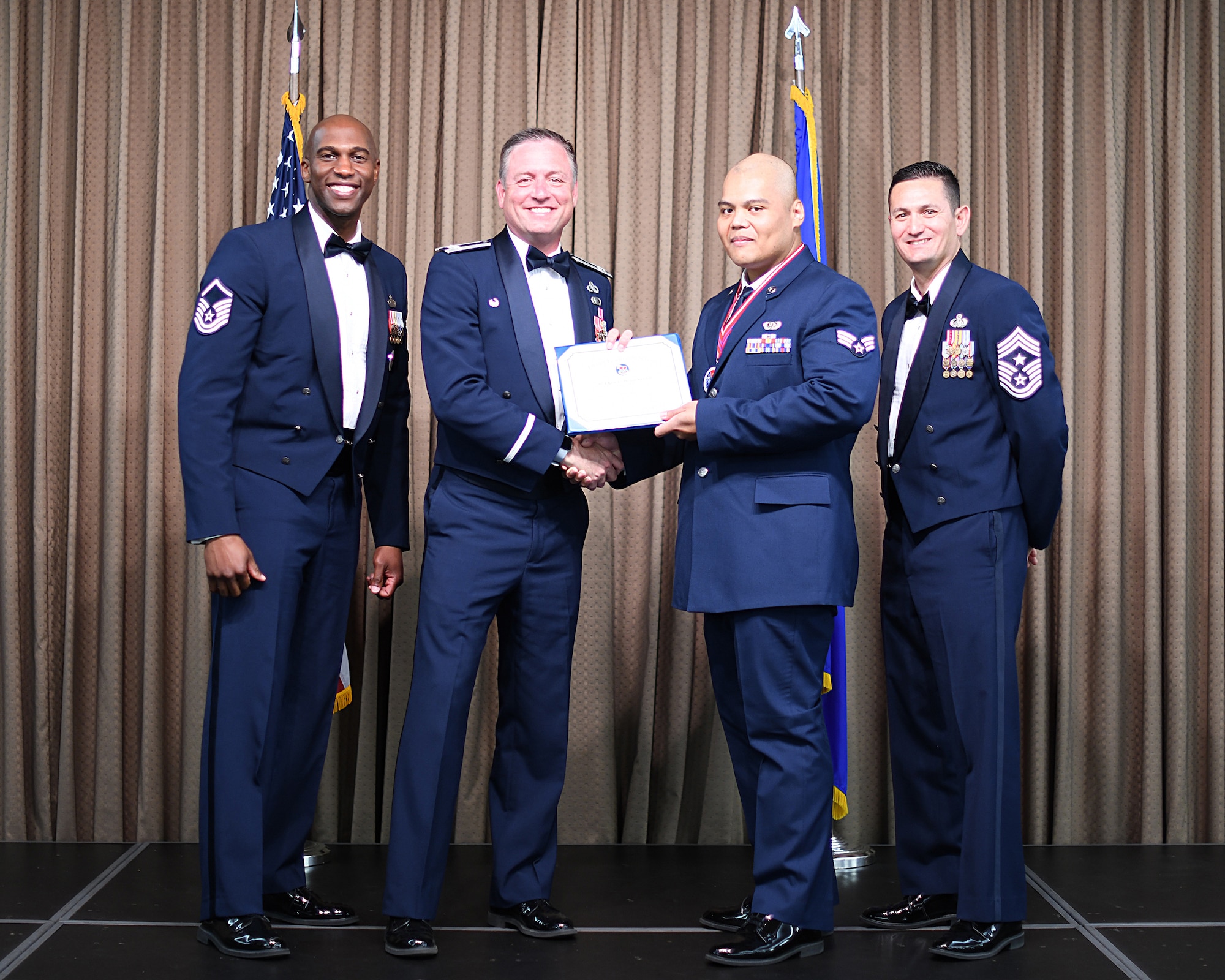 Col. Benjamin Spencer, 319th Air Base Wing commander, presents diploma to SrA Kim Delos Santos, Etchberger Airman Leadership School graduate, June 20, 2019, on Grand Forks Air Force Base, North Dakota. ALS graduation is the culmination of the first level of the Enlisted Professional Military Education continuum directed toward preparing upcoming noncommissioned officers with leadership skills for their careers. (U.S. Air Force photo by Senior Airman Elijaih Tiggs)