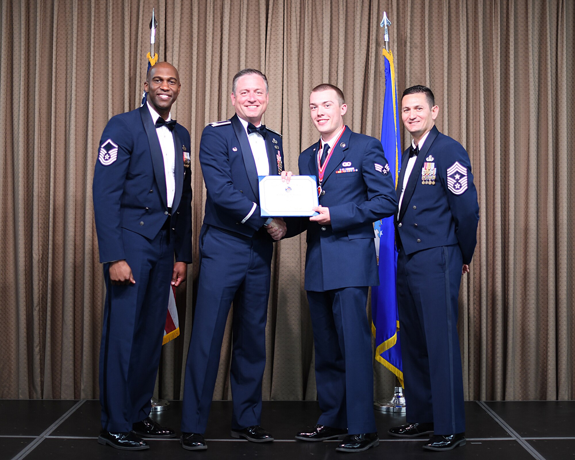 Col. Benjamin Spencer, 319th Air Base Wing commander, presents diploma to SrA Andrew Holman, Etchberger Airman Leadership School graduate, June 20, 2019, on Grand Forks Air Force Base, North Dakota. ALS graduation is the culmination of the first level of the Enlisted Professional Military Education continuum directed toward preparing upcoming noncommissioned officers with leadership skills for their careers. (U.S. Air Force photo by Senior Airman Elijaih Tiggs)