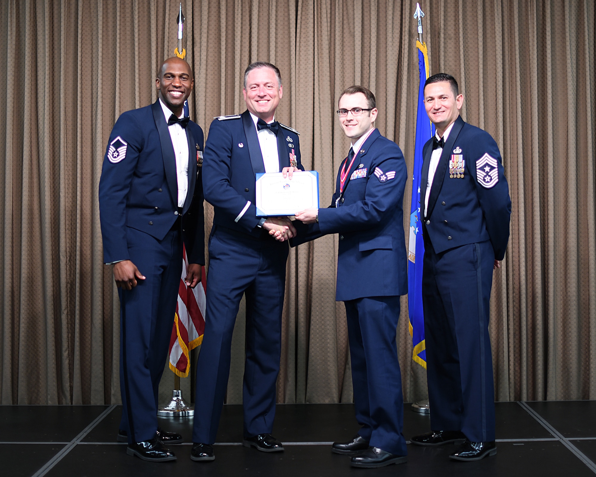 Col. Benjamin Spencer, 319th Air Base Wing commander, presents diploma to SrA Anthony Kline, Etchberger Airman Leadership School graduate, June 20, 2019, on Grand Forks Air Force Base, North Dakota. ALS graduation is the culmination of the first level of the Enlisted Professional Military Education continuum directed toward preparing upcoming noncommissioned officers with leadership skills for their careers.  (U.S. Air Force photo by Senior Airman Elijaih Tiggs)