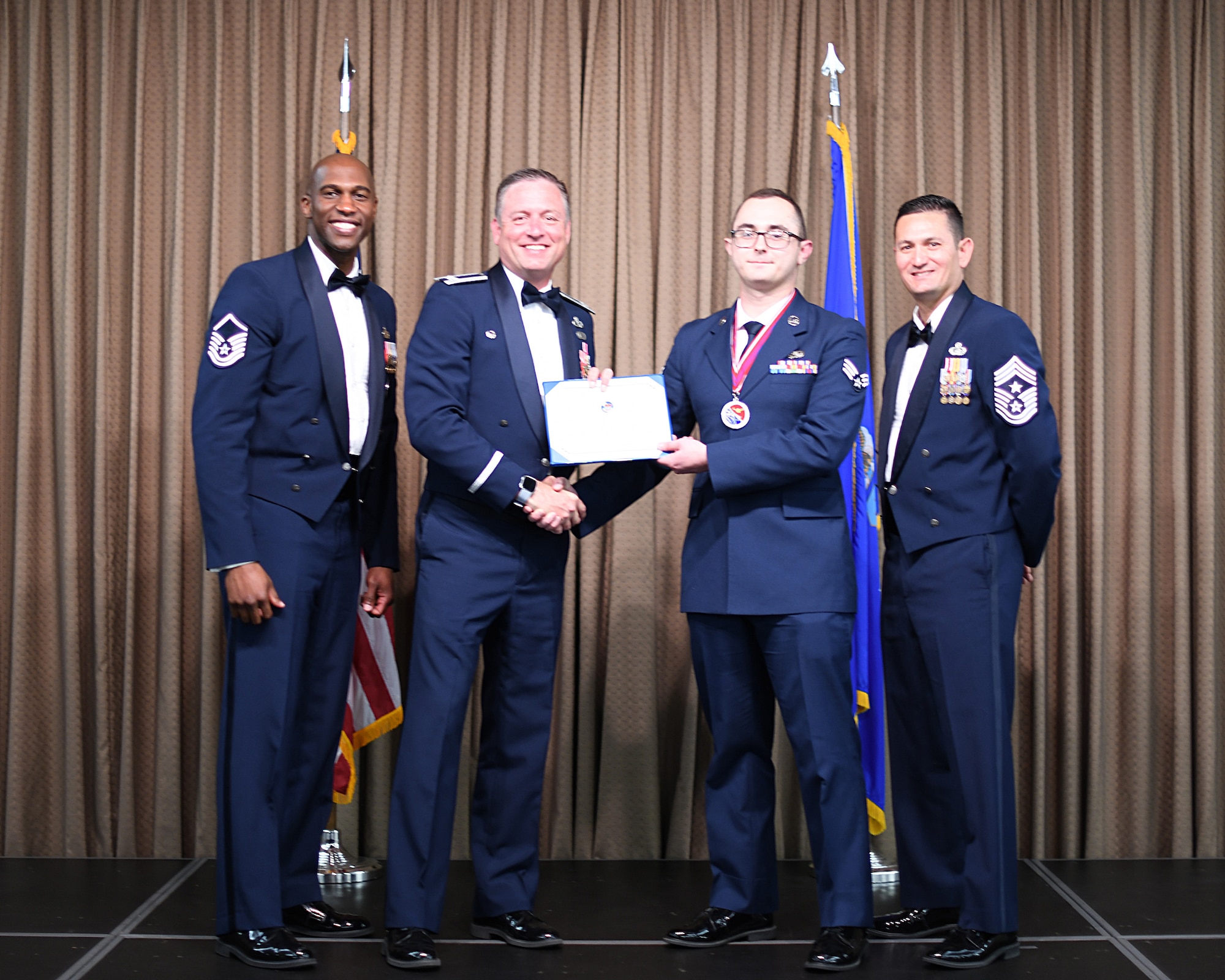 Col. Benjamin Spencer, 319th Air Base Wing commander, presents diploma to SrA Tyler Loper, Etchberger Airman Leadership School graduate, June 20, 2019, on Grand Forks Air Force Base, North Dakota. ALS graduation is the culmination of the first level of the Enlisted Professional Military Education continuum directed toward preparing upcoming noncommissioned officers with leadership skills for their careers. (U.S. Air Force photo by Senior Airman Elijaih Tiggs)
