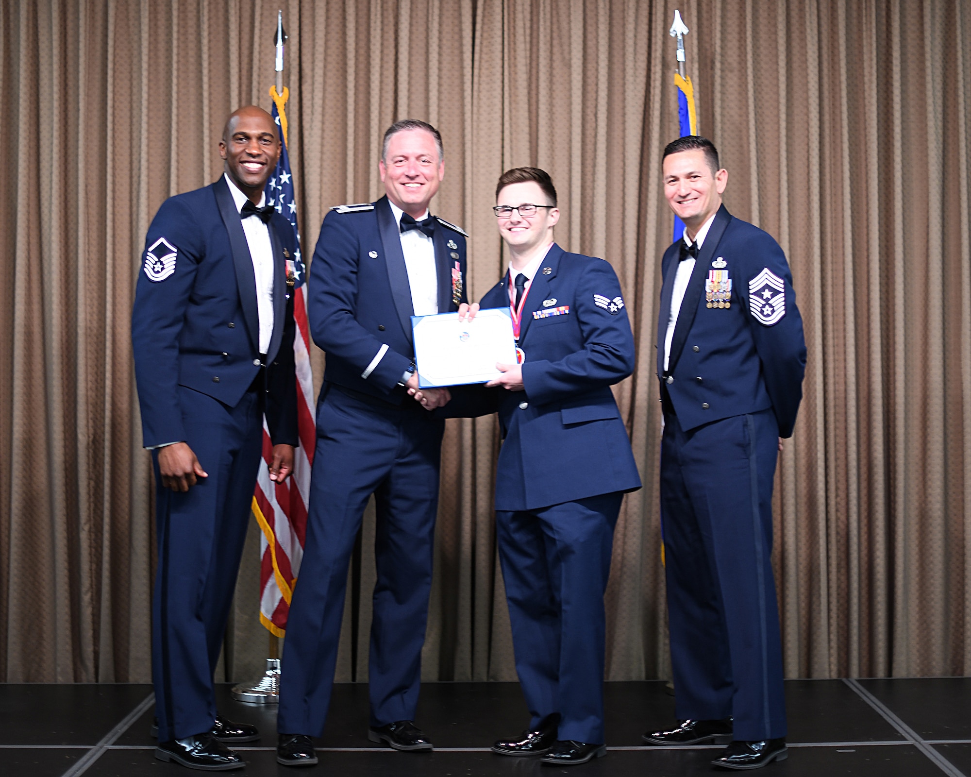 Col. Benjamin Spencer, 319th Air Base Wing commander, presents diploma to SrA Joseph Muskecitsch, Etchberger Airman Leadership School graduate, June 20, 2019, on Grand Forks Air Force Base, North Dakota. ALS graduation is the culmination of the first level of the Enlisted Professional Military Education continuum directed toward preparing upcoming noncommissioned officers with leadership skills for their careers. (U.S. Air Force photo by Senior Airman Elijaih Tiggs)