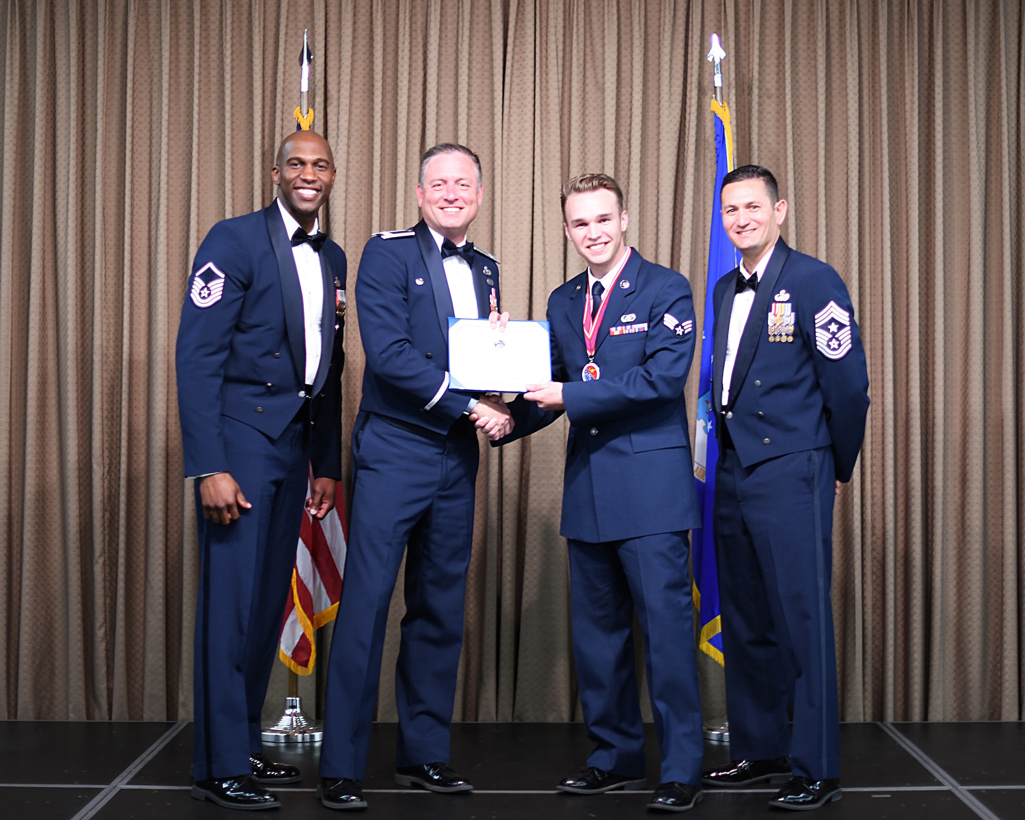 Col. Benjamin Spencer, 319th Air Base Wing commander, presents diploma to SrA Robert Olsen, Etchberger Airman Leadership School graduate, June 20, 2019, on Grand Forks Air Force Base, North Dakota. ALS graduation is the culmination of the first level of the Enlisted Professional Military Education continuum directed toward preparing upcoming noncommissioned officers with leadership skills for their careers. (U.S. Air Force photo by Senior Airman Elijaih Tiggs)