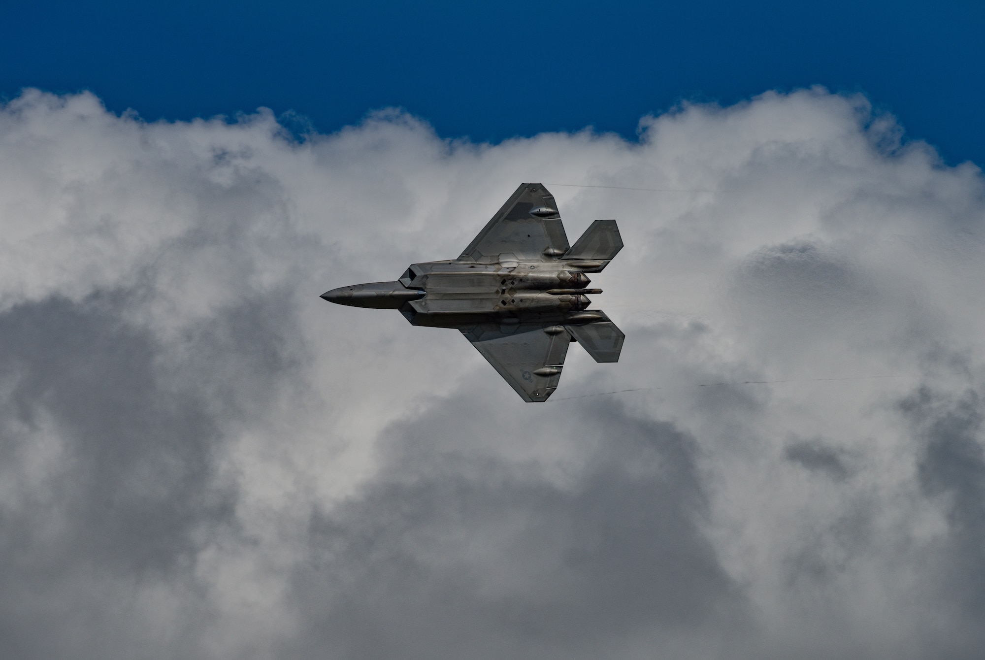 An F-22 Raptor assigned to the F-22 Demonstration Team banks right during a maneuver flight demonstration during the 2019 Wings Over Whiteman Air & Space Show at Whiteman Air Force Base, Missouri, June 15, 2019.  Based at Air Combat Command at Joint Base Fort Langley-Eustis, Virginia, the F-22 demonstration team tours the globe and showcases the fifth generation fighter's extraordinary maneuvarbility and lethality. (U.S. Air Force photo by Tech. Sgt. Alexander W. Riedel)