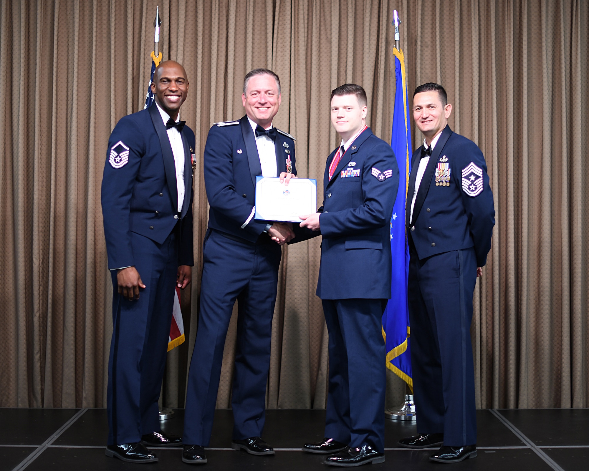 Col. Benjamin Spencer, 319th Air Base Wing commander, presents diploma to SrA Joseph Stockham, Etchberger Airman Leadership School graduate, June 20, 2019, on Grand Forks Air Force Base, North Dakota. ALS graduation is the culmination of the first level of the Enlisted Professional Military Education continuum directed toward preparing upcoming noncommissioned officers with leadership skills for their careers. (U.S. Air Force photo by Senior Airman Elijaih Tiggs)