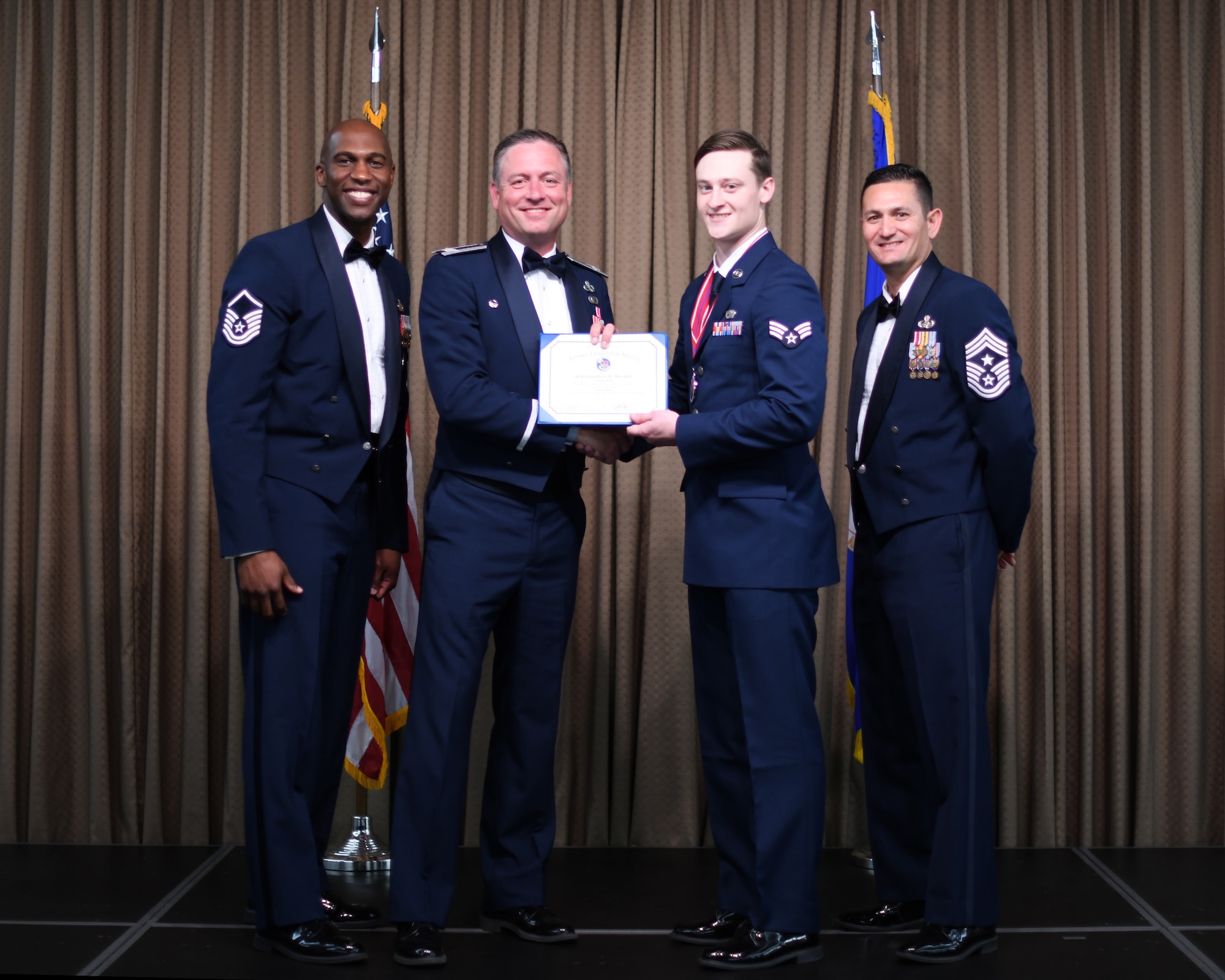 Col. Benjamin Spencer, 319th Air Base Wing commander, presents diploma to SrA Jonathan Wardell, Etchberger Airman Leadership School graduate, June 20, 2019, on Grand Forks Air Force Base, North Dakota. ALS graduation is the culmination of the first level of the Enlisted Professional Military Education continuum directed toward preparing upcoming noncommissioned officers with leadership skills for their careers. (U.S. Air Force photo by Senior Airman Elijaih Tiggs)