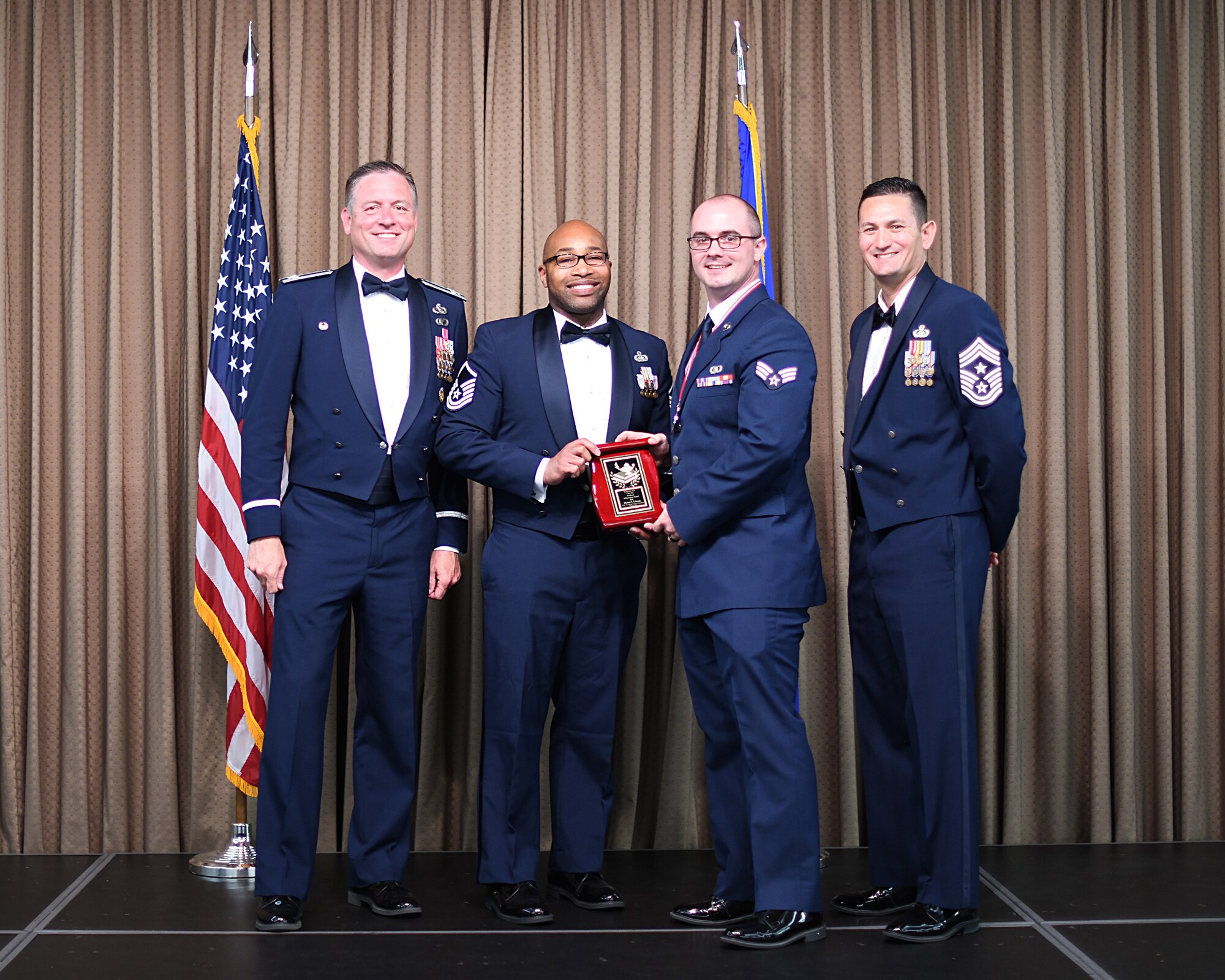 MSgt Kevin Davis, Air Force Sergeants Association representative, presents Academic Acheivement Award to SrA Michael Coleman, Etchberger Airman Leadership School graduate, June 20, 2019, on Grand Forks Air Force Base, North Dakota. ALS graduation is the culmination of the first level of the Enlisted Professional Military Education continuum directed toward preparing upcoming noncommissioned officers with leadership skills for their careers. (U.S. Air Force photo by Senior Airman Elijaih Tiggs)