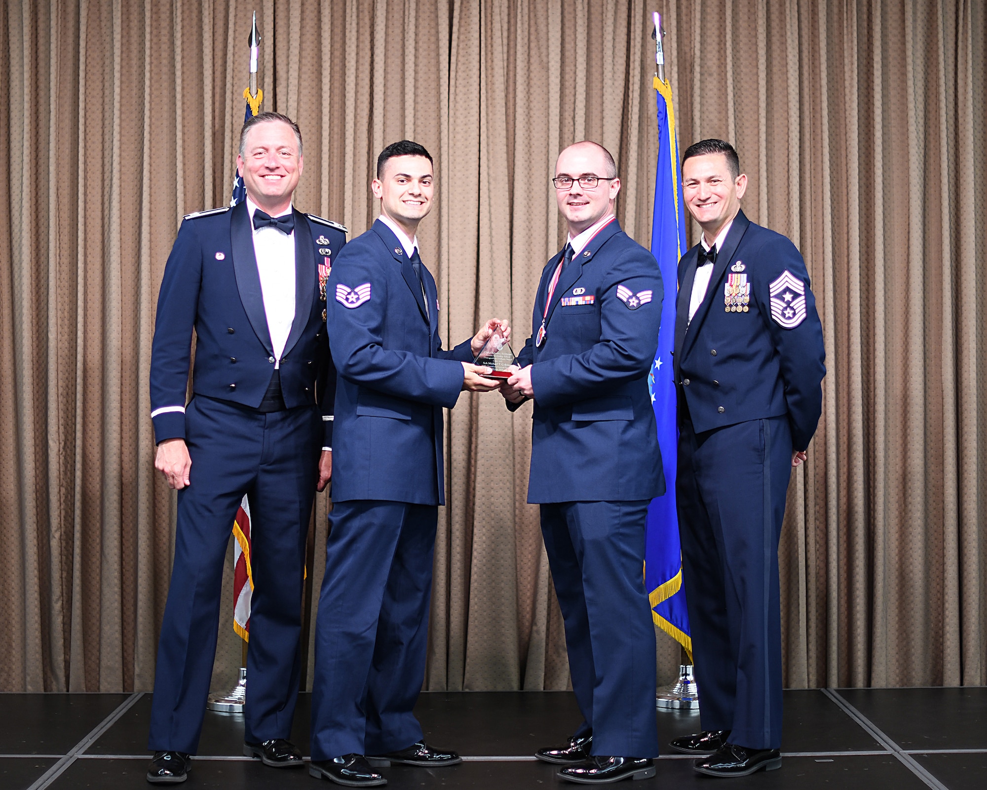 SSgt Matthew Romero, Network 5/6 representative, presents Distinguished Graduate Award to SrA Michael Coleman, Etchberger Airman Leadership School graduate, June 20, 2019, on Grand Forks Air Force Base, North Dakota. ALS graduation is the culmination of the first level of the Enlisted Professional Military Education continuum directed toward preparing upcoming noncommissioned officers with leadership skills for their careers. (U.S. Air Force photo by Senior Airman Elijaih Tiggs)
