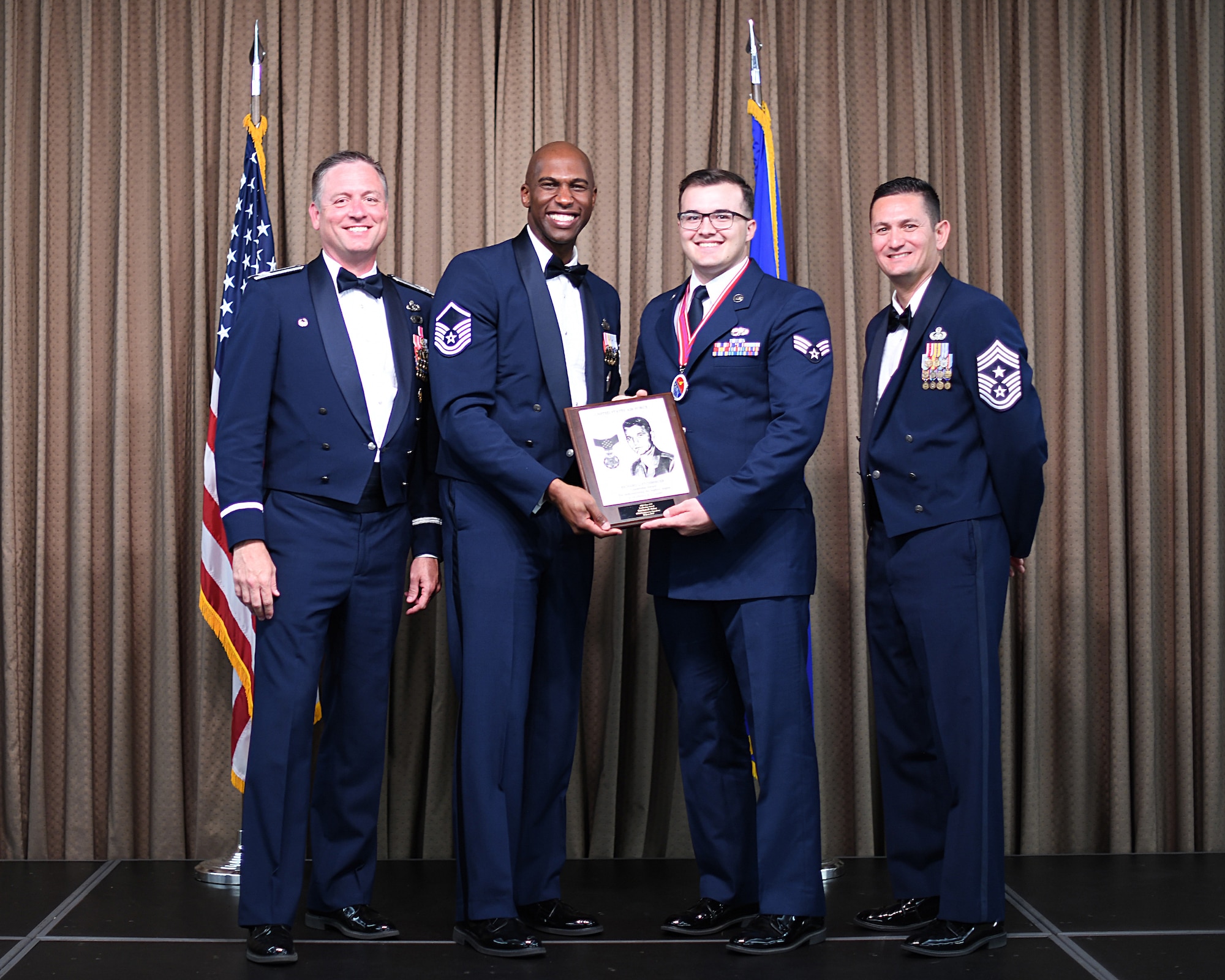 MSgt Leon Thomas, Etchberger Airman Leadership School commandant, presents Commandant's Leadership Award to SrA Lain Baker, Etchberger Airman Leadership School graduate, June 20, 2019, on Grand Forks Air Force Base, North Dakota. ALS graduation is the culmination of the first level of the Enlisted Professional Military Education continuum directed toward preparing upcoming noncommissioned officers with leadership skills for their careers. (U.S. Air Force photo by Senior Airman Elijaih Tiggs)