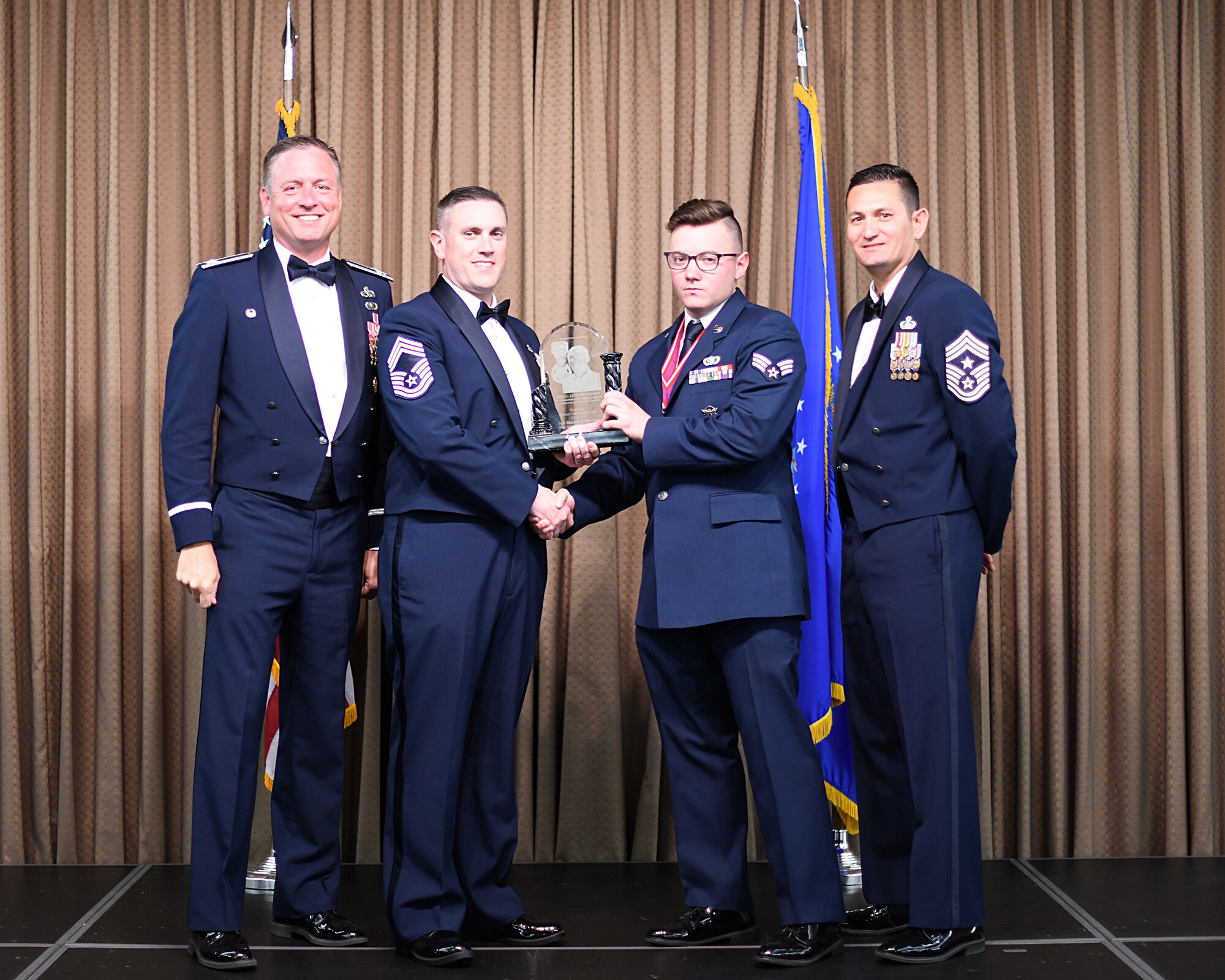 CMSgt David Allshouse, Chief's Group representative, presents John L. Levitow Award to SrA Maxwell Stebbins, Etchberger Airman Leadership School graduate, June 20, 2019, on Grand Forks Air Force Base, North Dakota. ALS graduation is the culmination of the first level of the Enlisted Professional Military Education continuum directed toward preparing upcoming noncommissioned officers with leadership skills for their careers. (U.S. Air Force photo by Senior Airman Elijaih Tiggs)