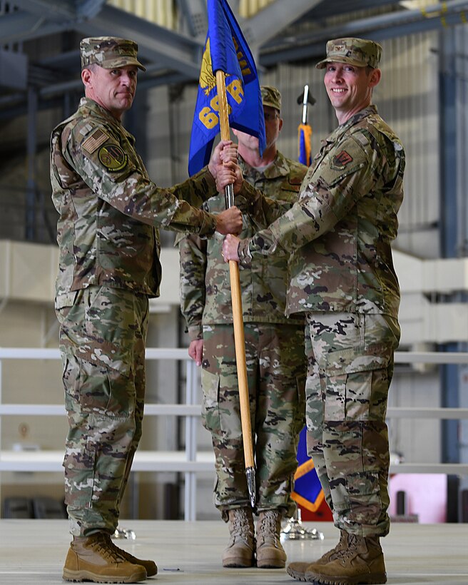 Col Andrew Clark presents Col Jeremy Fields with the 69th Reconnaissance Group's guidon during the 69 RG change of command ceremony as Fields assumes command of the 69 RG June 21, 2019, on Grand Forks Air Force Base, North Dakota. The 69 RG operates and maintains United States Air Force Global Hawk aircraft. (U.S. Air Force photo by Senior Airman Elijaih Tiggs)