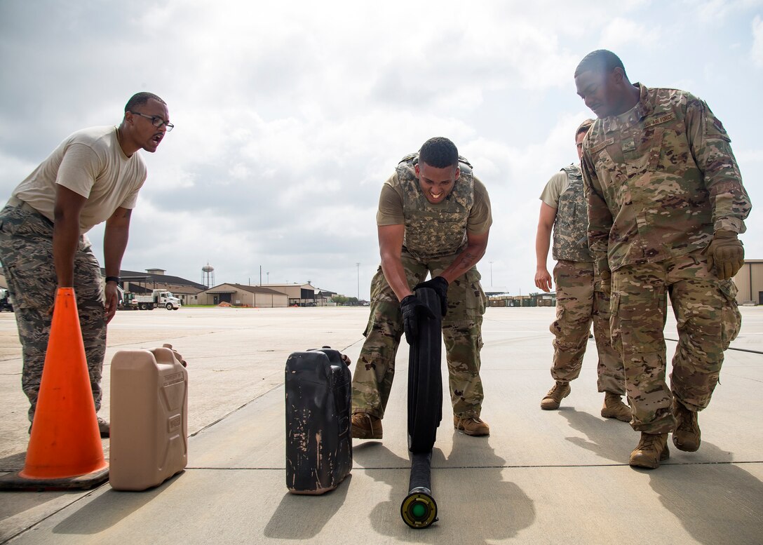Airman 1st Class John Miller, center, 23d Logistics Readiness Squadron fuels distribution operator, rolls up a fuel line hose during Forward Area Refueling Point (FARP) team tryouts, June 21, 2019, at Moody Air Force Base, Ga. The FARP team is comprised of elite fuels special operators whose mission is to provide needed fuel to aircraft in any environment in a swift manner. In order to become fully qualified, FARP team members must undergo a rigorous amount of continuous physical and mental training to ensure they’re fit for duty. Following the tryouts the Airmen were interviewed to further evaluate their mental readiness to join the FARP team and ultimately one Airman was chosen. (U.S. Air Force photo by Airman 1st Class Eugene Oliver)