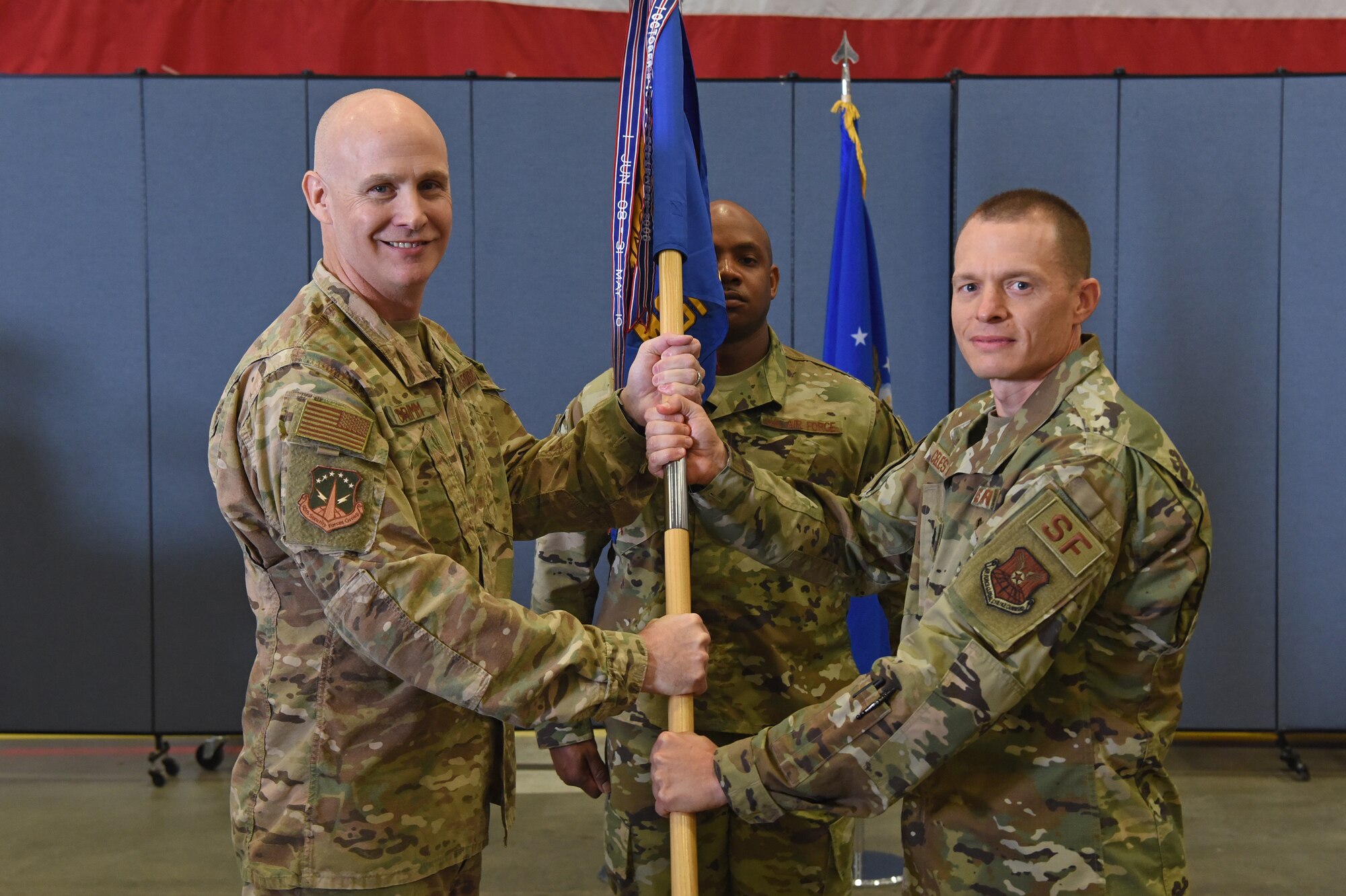 Colonel John Grimm, 90th Security Forces Group commander, passes the guidon to Lt. Col. David Celeste, 90th Missile Security Forces Squadron incoming commander, during the 90ths MSFS change of command ceremony June 26, 2019, on F.E. Warren Air Force Base, Wyo. The ceremony signified the transition of command from Lt. Col. Anthony McCarty to Celeste. (U.S. Air Force photo by Senior Airman Nicole Reed)