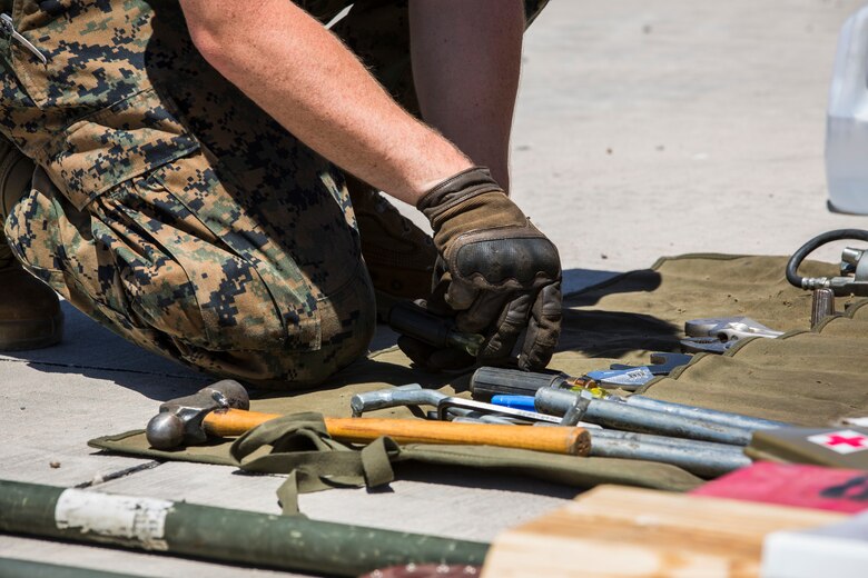 U.S. Marine Corps Motor Vehicle Operators assigned to Marine Unmanned Aerial Squadron (VMU) 1 gather issued gear together for placement in the 7-ton Medium Tactical Vehicle Replacement (MTVRs) and Humvee vehicles at Marine Corps Air Station Yuma, Ariz., June 18, 2019. The gear included basic vehicle repair items, tools, and first-aid items for the operators to use in case of emergency or mishap. (U.S. Marine Corps photo by Sgt. Isaac D. Martinez)