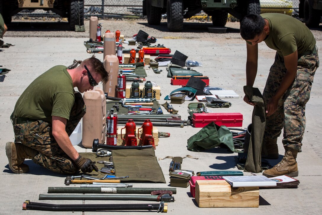 U.S. Marine Corps Motor Vehicle Operators assigned to Marine Unmanned Aerial Squadron (VMU) 1 gather issued gear together for placement in the 7-ton Medium Tactical Vehicle Replacement (MTVRs) and Humvee vehicles at Marine Corps Air Station Yuma, Ariz., June 18, 2019. The gear included basic vehicle repair items, tools, and first-aid items for the operators to use in case of emergency or mishap. (U.S. Marine Corps photo by Sgt. Isaac D. Martinez)