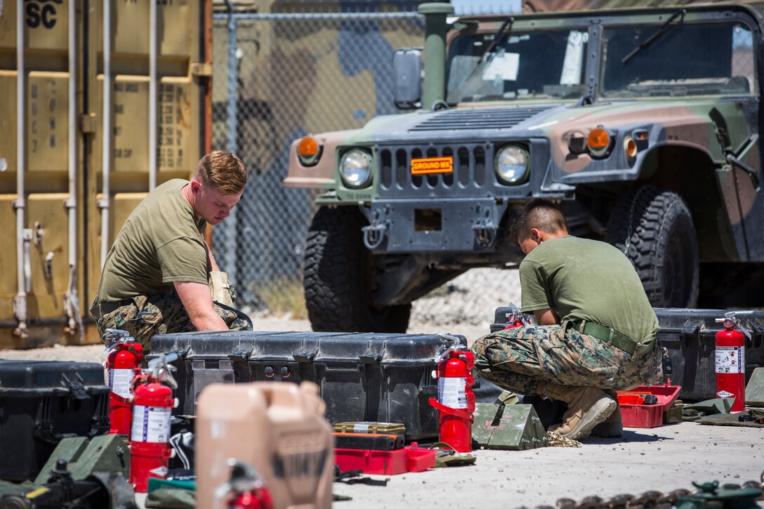 U.S. Marine Corps Motor Vehicle Operators assigned to Marine Unmanned Aerial Squadron (VMU) 1 gather issued gear together for placement in the 7-ton Medium Tactical Vehicle Replacement (MTVRs) and Humvee vehicles at Marine Corps Air Station Yuma, Ariz., June 18, 2019. The gear included basic vehicle repair items, tools, and first-aid items for the operators to use in case of emergency or mishap. (U.S. Marine Corps photo by Sgt. Isaac D. Martinez)