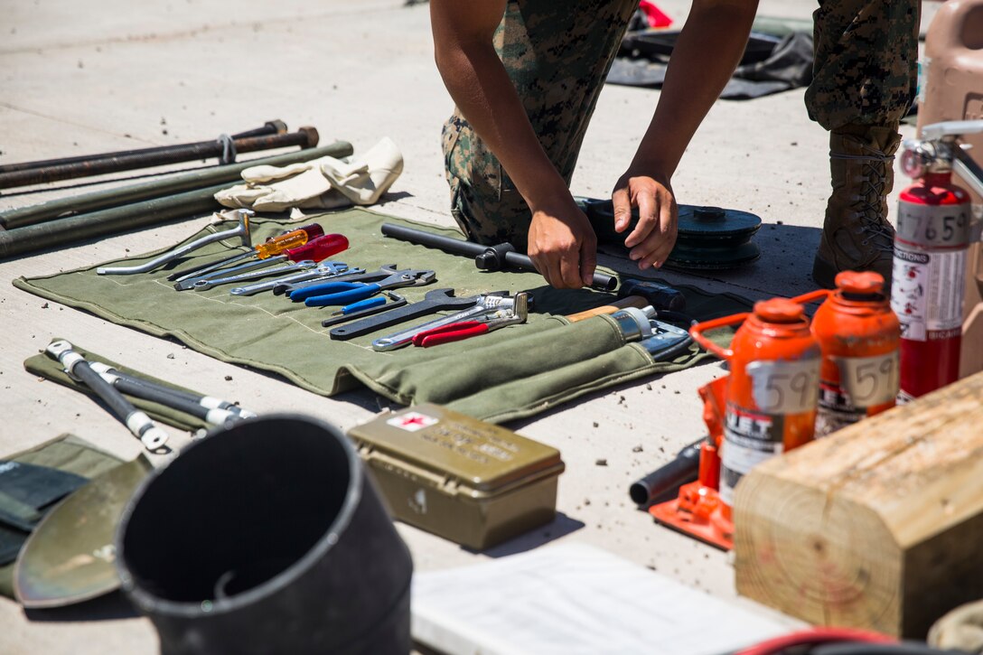 U.S. Marine Corps Motor Vehicle Operators assigned to Marine Unmanned Aerial Squadron (VMU) 1 gather issued gear together for placement in the 7-ton Medium Tactical Vehicle Replacement (MTVRs) and Humvee vehicles at Marine Corps Air Station Yuma, Ariz., June 18, 2019. The gear included basic vehicle repair items, tools, and first-aid items for the operators to use in case of emergency or mishap. (U.S. Marine Corps photo by Sgt. Isaac D. Martinez)