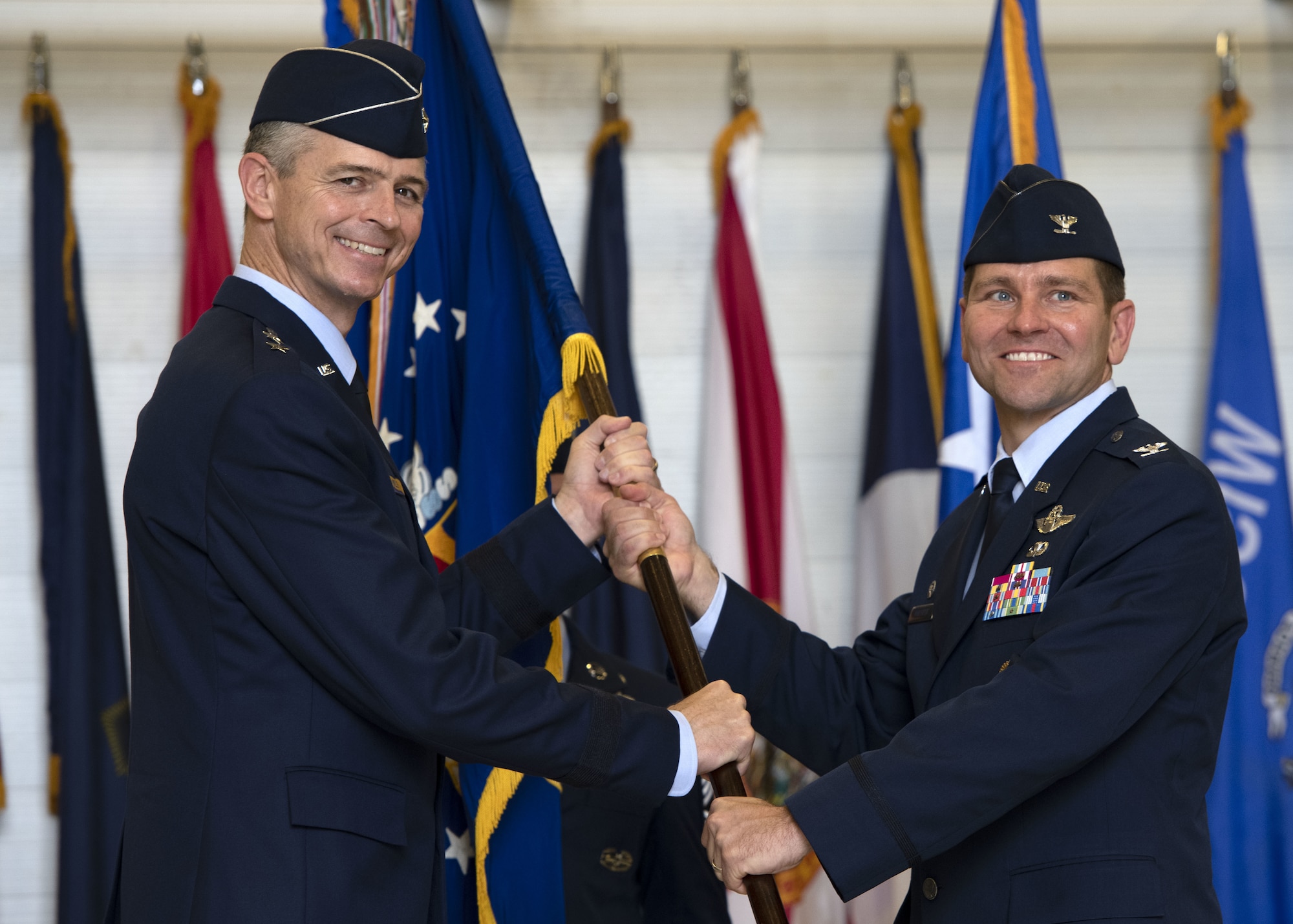 U.S. Air Force Col. Jon Wheeler, incoming 33rd Fighter Wing commander, takes the guidon from U.S. Maj. Gen. Craig Wills, 19th AF commander, during a change of command ceremony at Eglin Air Force Base, Florida, June 18, 2019.