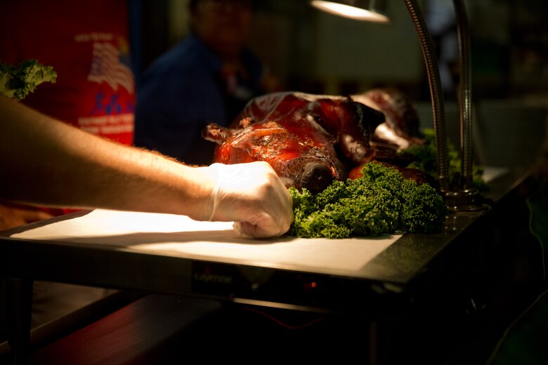 U.S. Marines stationed at Marine Corps Air Station (MCAS) Yuma are served a Traditional Pig Roast at the mess hall on MCAS Yuma Ariz., June 19, 2019. The roasted pig is part of MCAS Yuma’s annual Hawaiian Luau Meal, which is intended to raise the spirits and fill the bellies of the Marines and Sailors stationed at MCAS Yuma. (U.S. Marine Corps photo by Cpl. Joel Soriano)