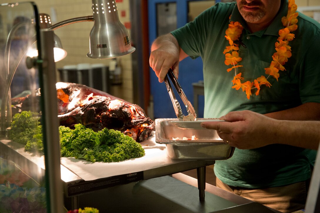 U.S. Marines stationed at Marine Corps Air Station (MCAS) Yuma are served a Traditional Pig Roast at the mess hall on MCAS Yuma Ariz., June 19, 2019. The roasted pig is part of MCAS Yuma’s annual Hawaiian Luau Meal, which is intended to raise the spirits and fill the bellies of the Marines and Sailors stationed at MCAS Yuma. (U.S. Marine Corps photo by Cpl. Joel Soriano)