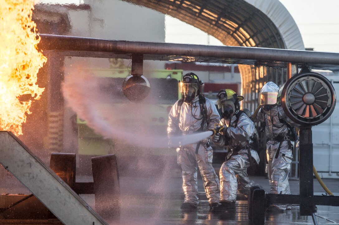 U.S. Marines with Aircraft Rescue and Firefighting (ARFF), Headquarters and Headquarters Squadron (H&HS), Marine Corps Air Station (MCAS) Yuma conduct hand line drills during live burn training on MCAS Yuma, Ariz., June 25, 2019. Hand line drills focus on techniques to push fuel fires away from aircraft, ARFF Marines train monthly to enhance their readiness when responding to emergencies on the flight line. (U.S. Marine Corps photo by Sgt. Allison Lotz)