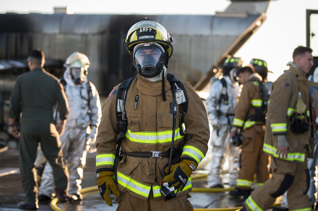 U.S. Marines with Aircraft Rescue and Firefighting (ARFF), Headquarters and Headquarters Squadron (H&HS), Marine Corps Air Station (MCAS) Yuma conduct hand line drills during live burn training on MCAS Yuma, Ariz., June 25, 2019. Hand line drills focus on techniques to push fuel fires away from aircraft, ARFF Marines train monthly to enhance their readiness when responding to emergencies on the flight line. (U.S. Marine Corps photo by Sgt. Allison Lotz)