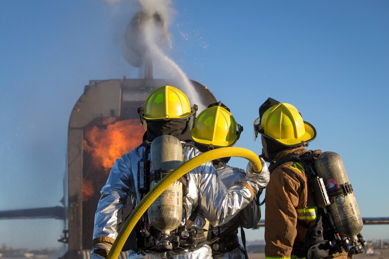 U.S. Marines with Aircraft Rescue and Firefighting (ARFF), Headquarters and Headquarters Squadron (H&HS), Marine Corps Air Station (MCAS) Yuma conduct hand line drills during live burn training on MCAS Yuma, Ariz., June 25, 2019. Hand line drills focus on techniques to push fuel fires away from aircraft, ARFF Marines train monthly to enhance their readiness when responding to emergencies on the flight line. (U.S. Marine Corps photo by Sgt. Allison Lotz)