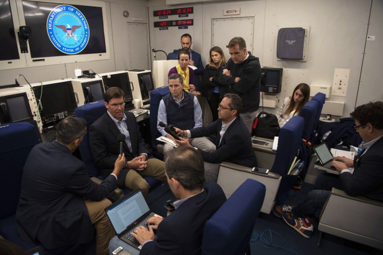 Reporters interview the acting defense secretary en route to Brussels.