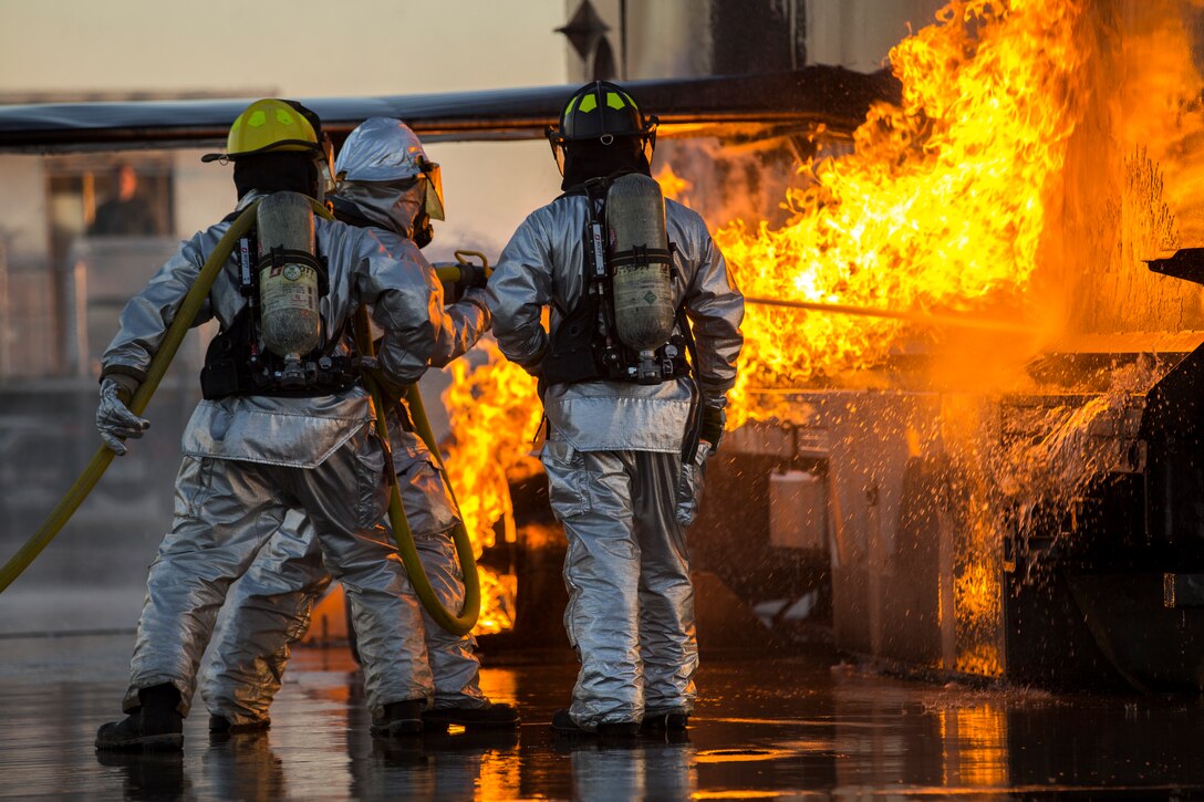 U.S. Marines with Aircraft Rescue and Firefighting (ARFF), Headquarters and Headquarters Squadron (H&HS), Marine Corps Air Station (MCAS) Yuma conduct hand line drills during live burn training on MCAS Yuma, Ariz., June 25, 2019. Hand line drills focus on techniques to push fuel fires away from aircraft, ARFF Marines train monthly to enhance their readiness when responding to emergencies on the flight line. (U.S. Marine Corps photo by Lance Cpl. John Hall)